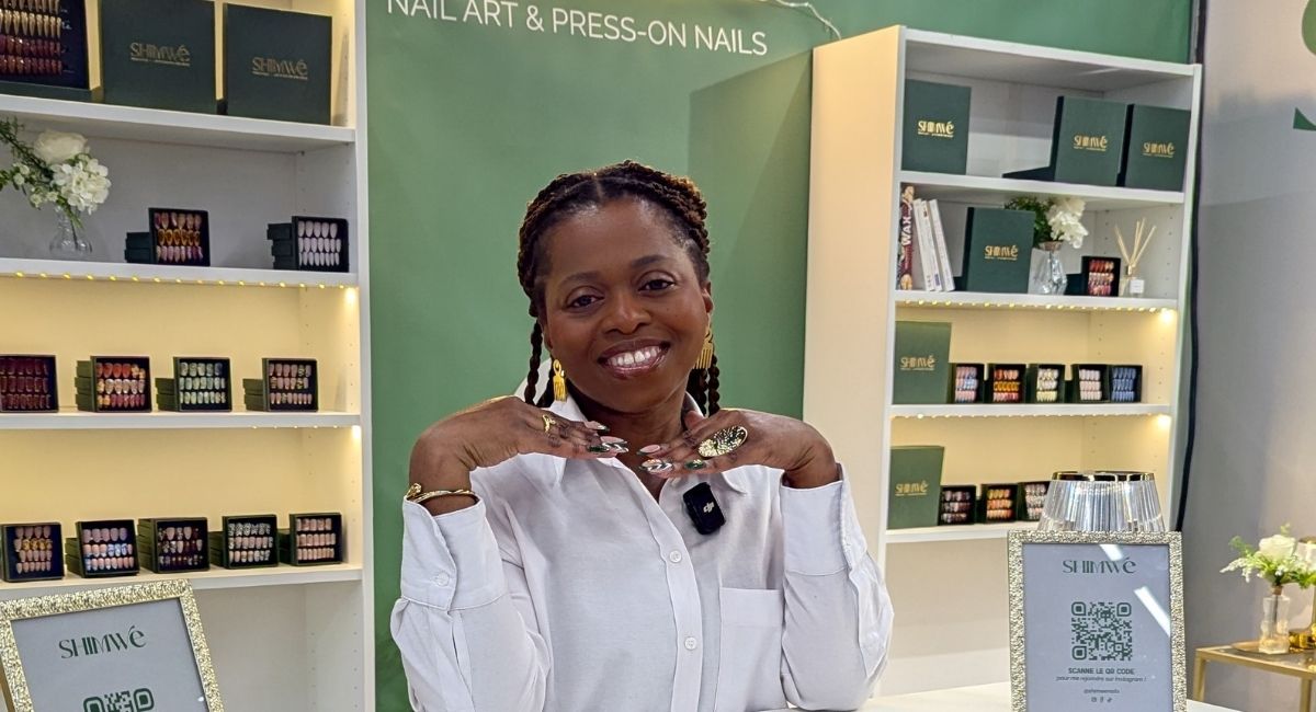 Sandrine, artisan nail artist et fondatrice de SHIMWE, derrière son comptoir présentant ses collections de faux ongles personnalisés et réutilisables